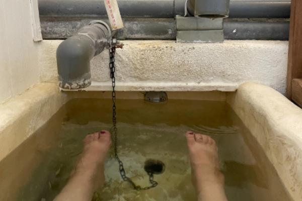 Legs soaking in mineral hot springs bathtub water